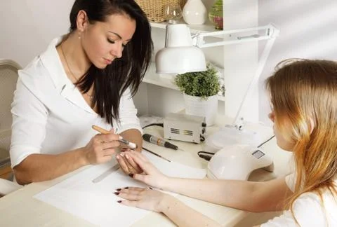 Manicurist does manicure for client Фото