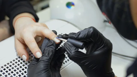 A manicurist does the procedure to care for the nails of a client in a beauty Stock Footage 129173400