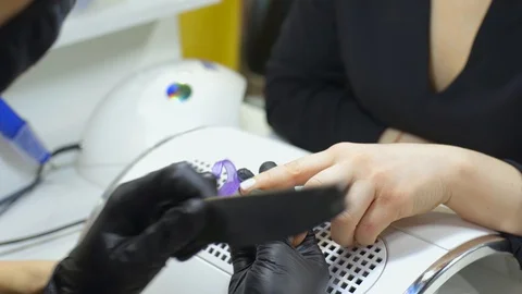 A manicurist does the procedure to care for the nails of a client in a beauty Stock Footage 129173741
