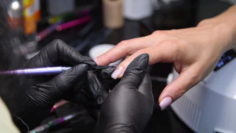 A manicurist is doing a client&amp;#039;s nails at a nail salon. Stock Footage 339780353