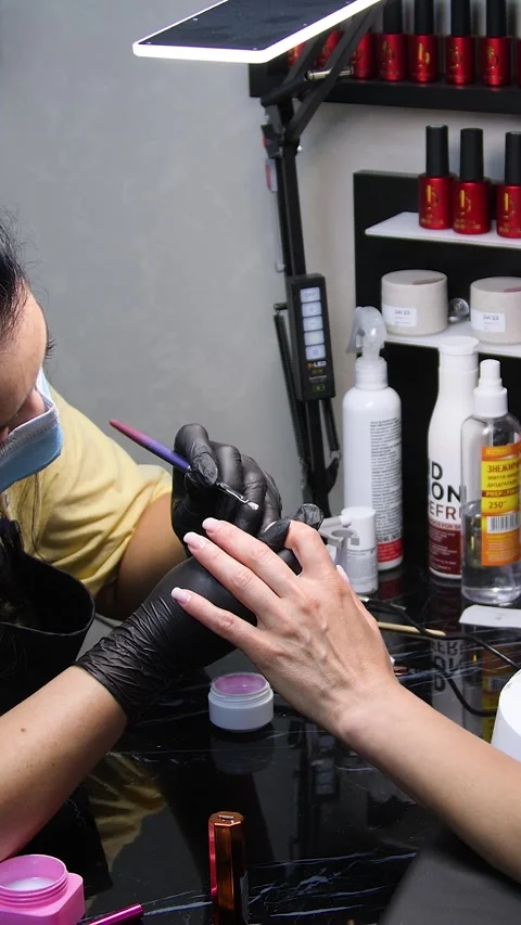 A manicurist is doing a client&amp;#039;s nails at a nail salon. Stock Footage 339781186