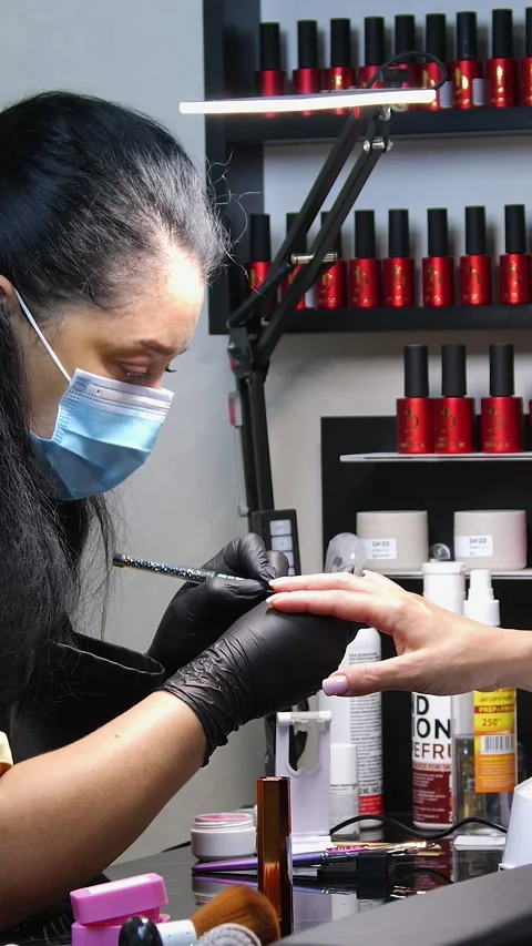 A manicurist is doing a client&amp;#039;s nails at a nail salon. Stock Footage 339781203