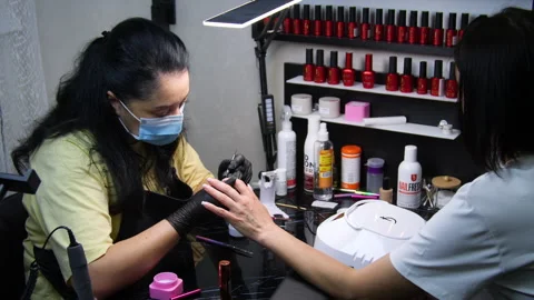 A manicurist is doing a client's nails at a nail salon. Stock Footage 339780361