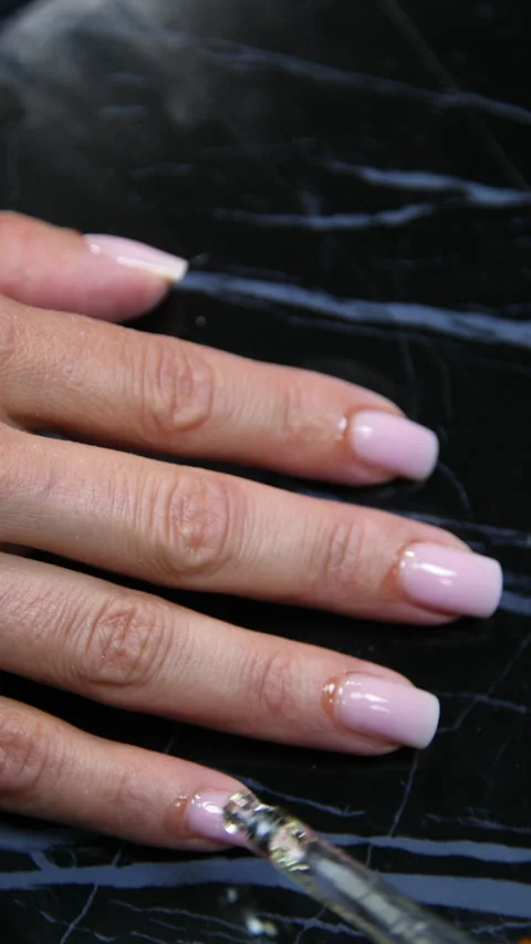 A manicurist is doing a client's nails at a nail salon. Stock Footage 339780973