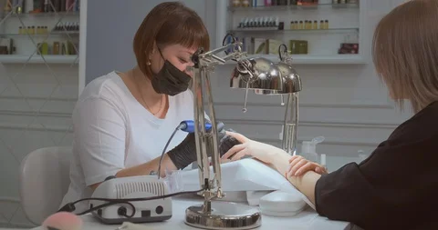 Manicurist files client nails with machine in salon 库存影片 128889808