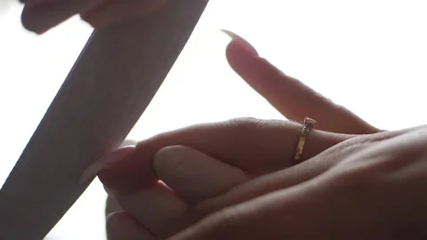 Manicurist files the shape of the nails with a special nail file, close up view Stock Footage 295814898