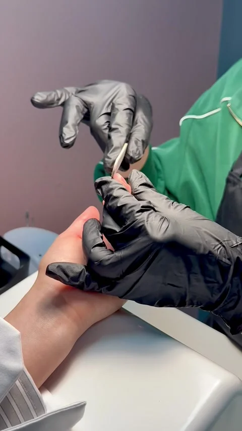 Manicurist in gloves files shape of nails. Nail art master shapes the nails with Stock Footage 324868665
