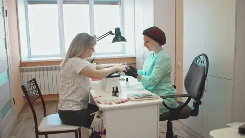 The manicurist holds the hands of the client while examining the hands Video stock 152988350
