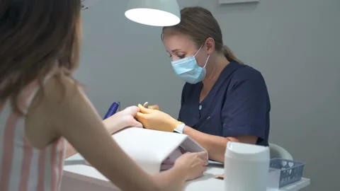 The manicurist makes the shape of the nails with a hard file for the client 库存影片 165222661