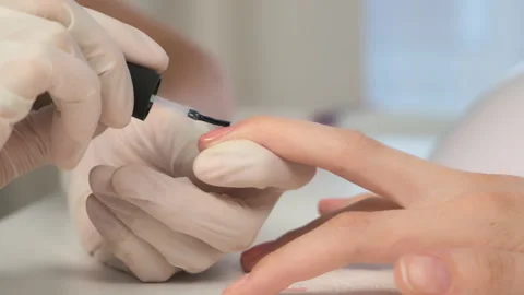 Manicurist master is applying top coat on pink gel on client nails in salon. Stock Footage 145763205