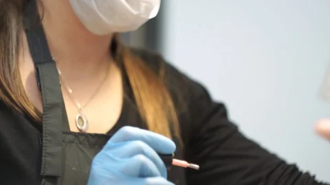 Manicurist paints the nails of a client. Close-up of her eyes Stock Footage 126171127