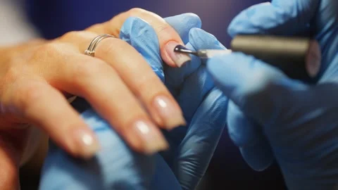 A manicurist performs detailed work of applying gel base. Stock Footage 315311456