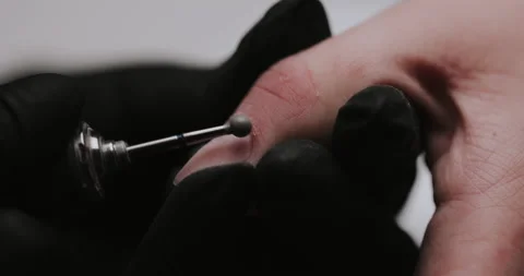 The manicurist processes the client's cuticle with a hardware machine.  Video stock 149366888