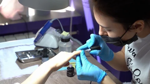 Manicurist professionally handles nails for his client Stock-Footage 129907053