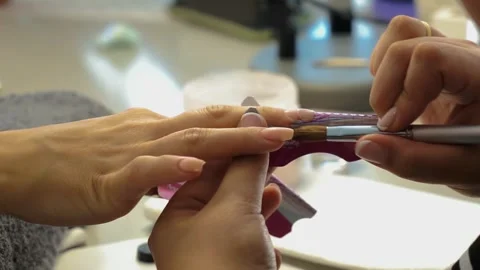 Manicurist putting some false gel nails in a beauty center Stock Footage 252135607