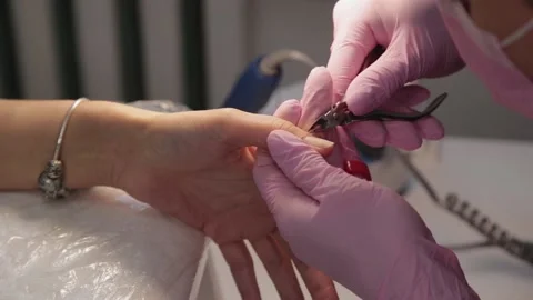 Manicurist removes cuticles with forceps. 库存影片 133082265