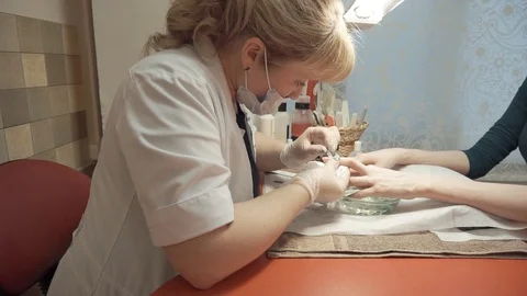 Manicurist removing cuticles sideview Stock Footage 87825363