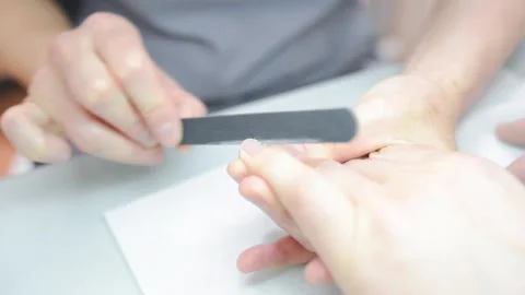 A manicurist saws a man's nails Stock Footage 132105084