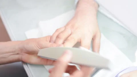 A manicurist saws a man's nails Stock Footage 132105326