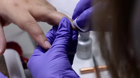 A manicurist treating a woman's cuticles with moisturizing wipe Stock Footage 258333387