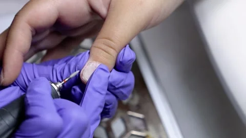 A manicurist treating a woman's cuticles using a manicure machine Stock Footage 256504026