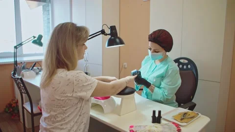 The manicurist uses a nail file to process the client's nails. Stock Footage 152986820