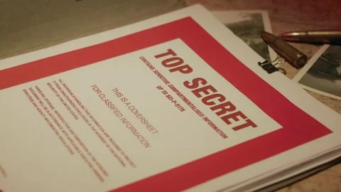 A manilla folder containing 'Top Secret' documents is lit by subdued light Stock Footage 233283623