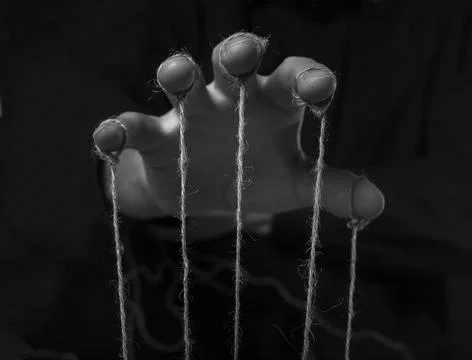 Manipulation concept. Hand of abuser manipulate with string Foto stock