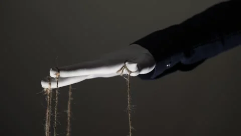 Manipulator hands in white gloves with ropes on fingers Stock Footage 253370608