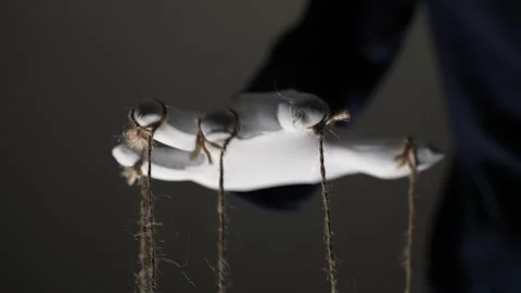 Manipulator hands in white gloves with ropes on fingers Stock Footage 253370733