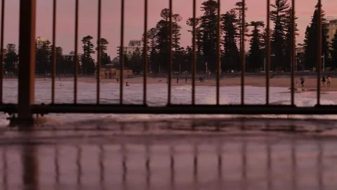 Manly beach at sunset in Australia seen through reflected fencing slomo Stock Footage 259244715