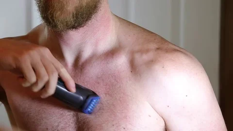 Manly man manscaping his chest hair in mirror Stock Footage 72194882