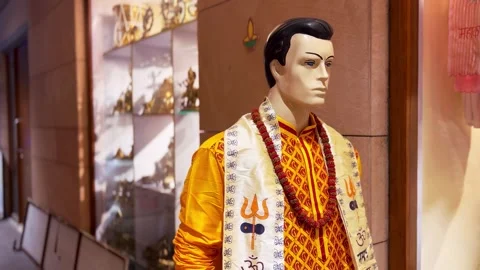 Mannequin displaying a bright orange sherwani with religious symbols Stock Footage 285420853