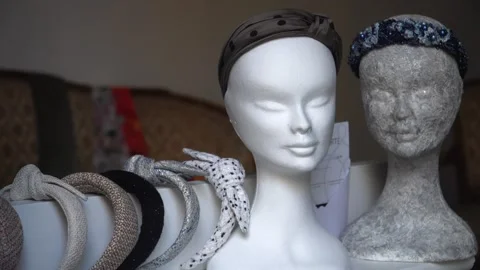Mannequin heads in a store window display a headband collection Stock Footage 289655565
