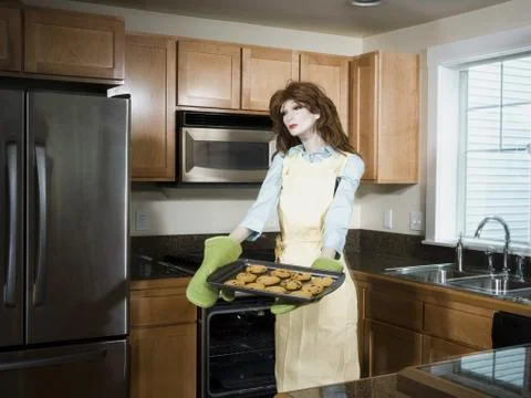 Mannequin portraying a woman holding a tray of biscuits Stock Photos
