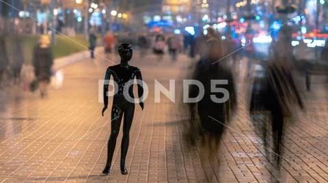 The mannequin standing on the evening street with people Stock Photos