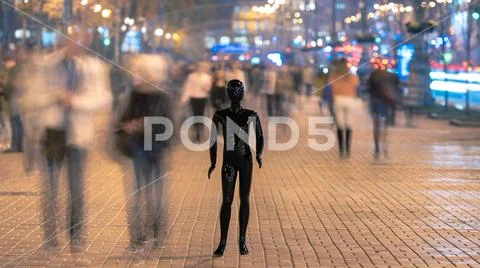 The mannequin stands on the street among the stream of people Stock Photos