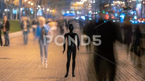 The mannequin stands on the street among the stream of people Stock Photos