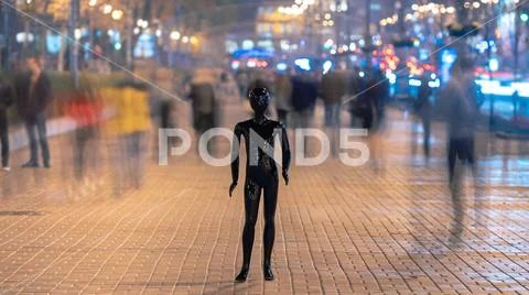 The mannequin stands on the street among the stream of people Stock Photos