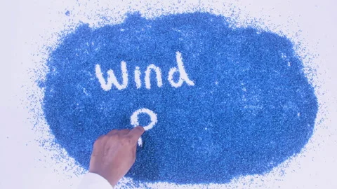 Man's arm writing in the blue particles the word Wind power Stock Footage 248537833