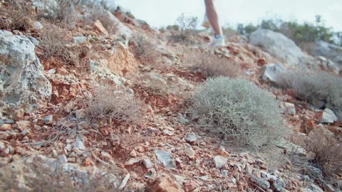 A mans athletic training, climbing up a rocky scorched mountain upwards Stock Footage 311601642