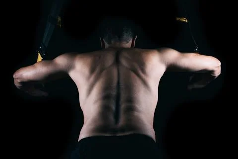 Man's back exercising with a trx Stock Photos