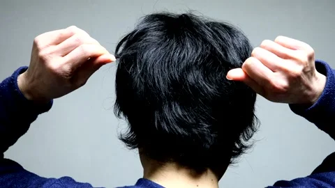 A man's back as he styles his hair. Stock-Footage 336187504