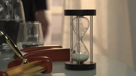 Man's come to the table and turned the sand clock to ON. Stock Footage 60814267