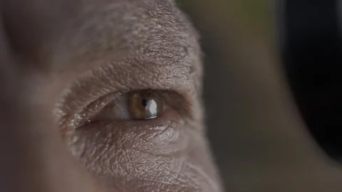 Man's eye with deep skin texture looks into an optical instrument. Stock-Footage 270064832