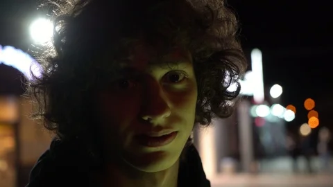 Man's face illuminated of multicolor side light outdoors at night, 4k 2 Stock Footage 95624748