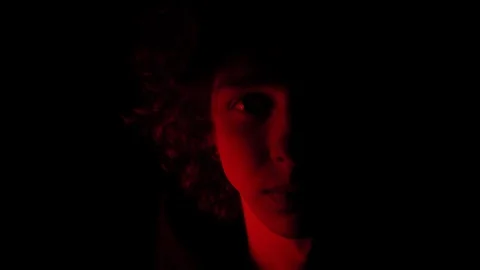 Man's face illuminated of red light in the darkness,half face , 4k Видео 95624873