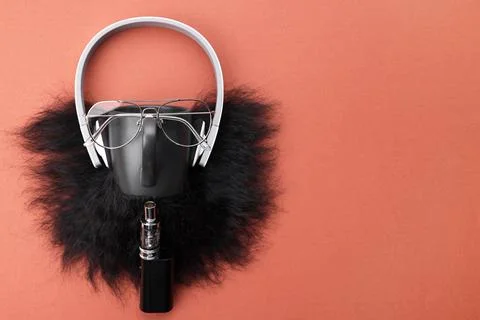 Man's face made of artificial beard, headphones and glasses on terracotta b.. Stock Photos