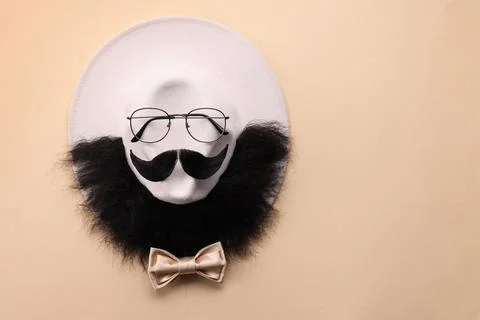 Man's face made of artificial mustache, beard and glasses on beige backgrou.. Stock Photos