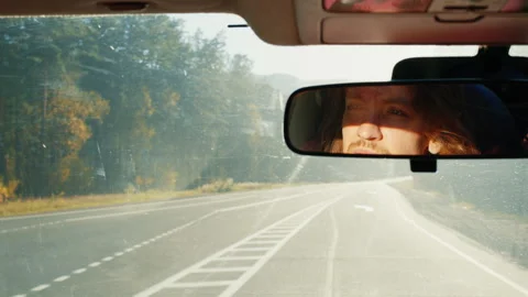 Man's face reflecting in car rearview mirror while driving Stock Footage 335215034